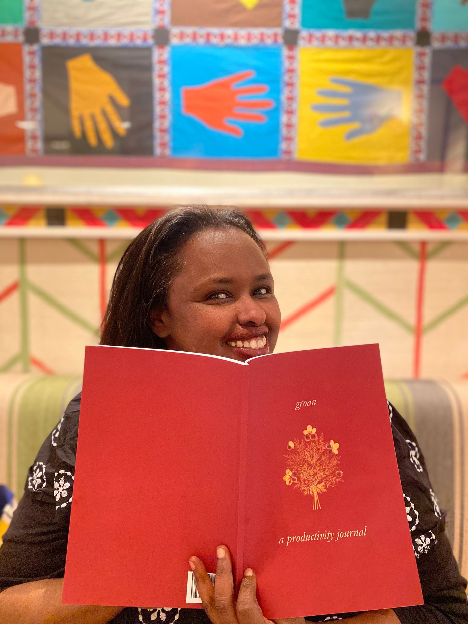 portrait of Nima Kanyare, founder of Crafted for Living, holding a printed copy of groan - a productivity journal